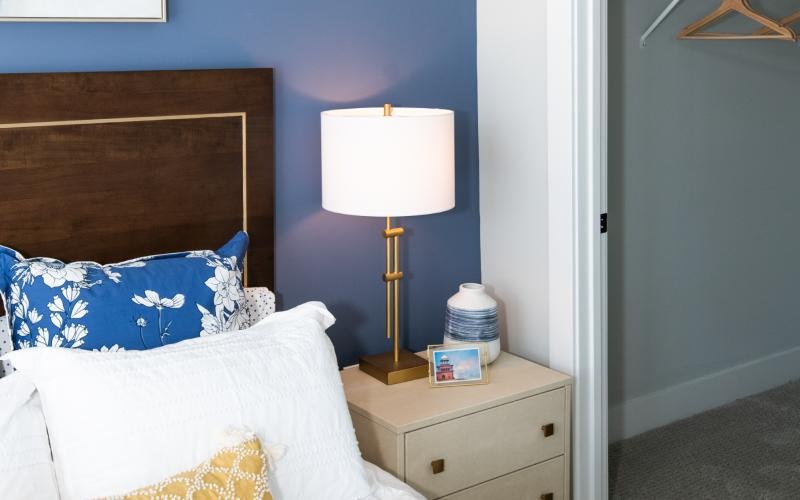 a bedroom with a bed lamp and closet