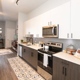 a large kitchen with white cupboards and stainless steel appliances