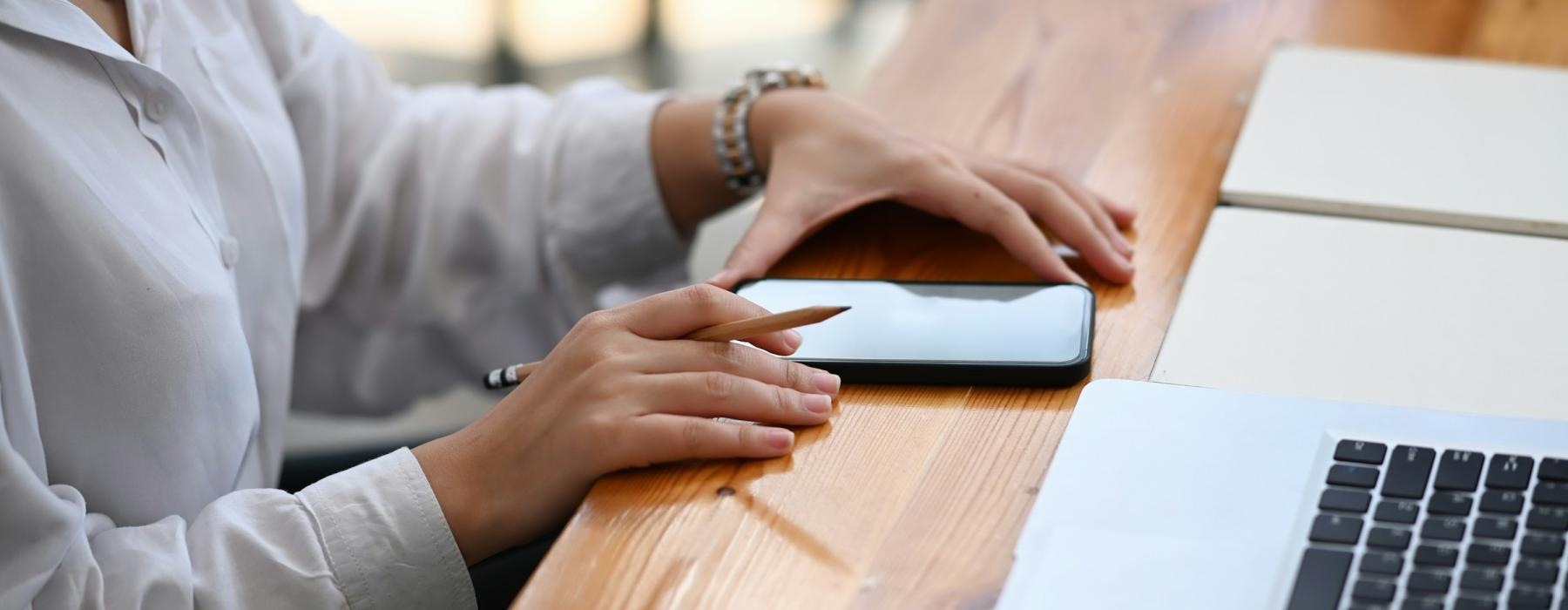 a person with a phone and a laptop